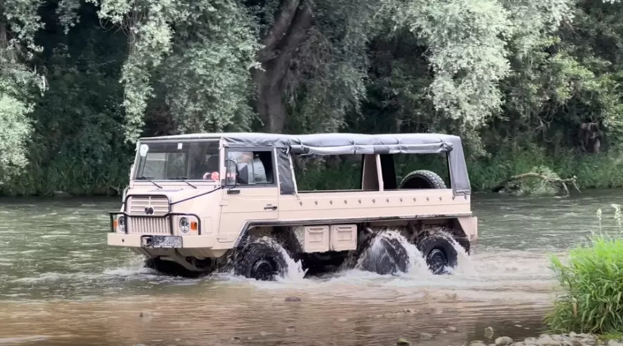 beiger Geländewagen mit sechs Reifen in Fluss