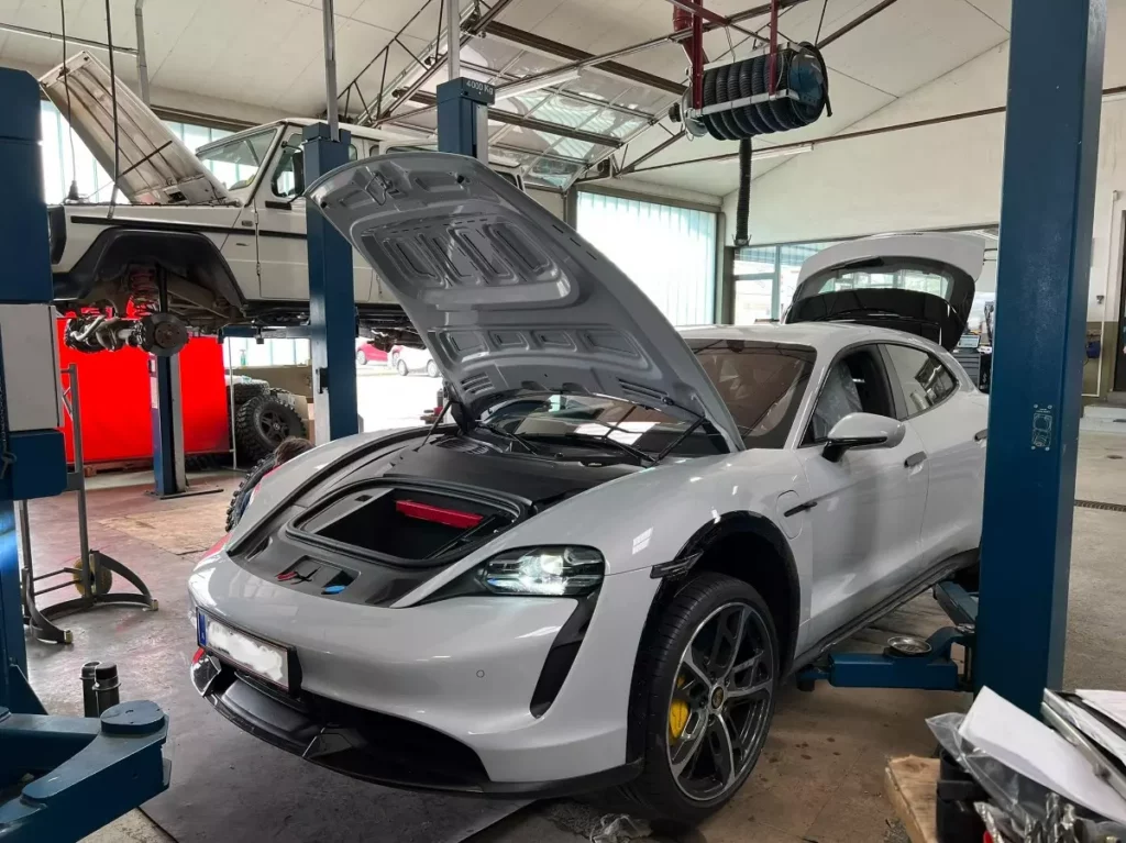 grauer Porsche in Autowerkstatt in Laa mit geöffneter Motorhaube und Kofferraum
